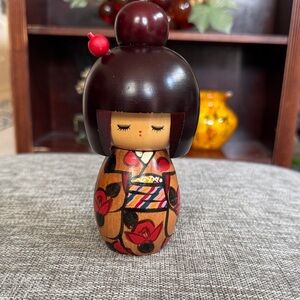 Handcrafted Wooden Doll with Red Floral Accents